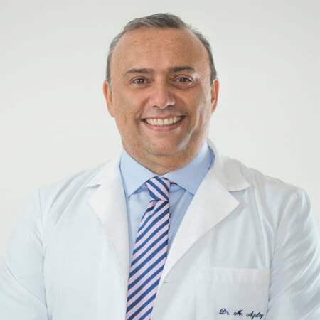 Picture of a smiling fertility doctor in San José, Costa Rica.  The doctor is looking directly at the camera, and is wearing a blue striped tie and a white coat.